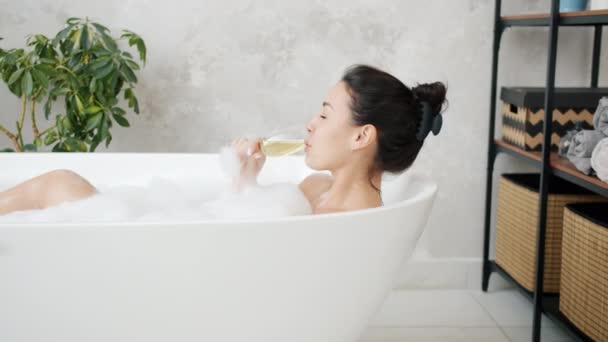 Krásná dáma pije šampaňské s úsměvem relaxaci ve vaně doma — Stock video