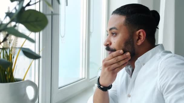 Hombre afroamericano guapo mirando a la ventana y luego bebiendo café en casa solo — Vídeo de stock