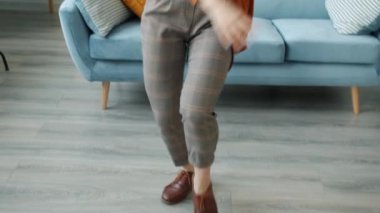 Evde kulaklık takan, dans eden ve şarkı söyleyen mutlu bir öğrenci.