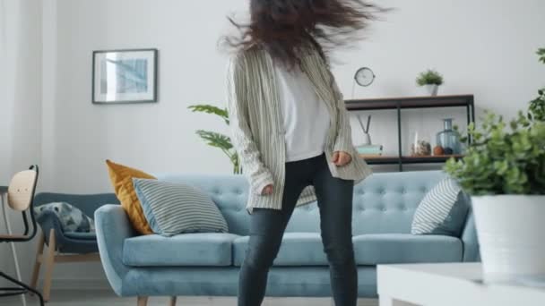 Portret van leuke jonge vrouw dansen alleen thuis genieten van muziek chillen — Stockvideo