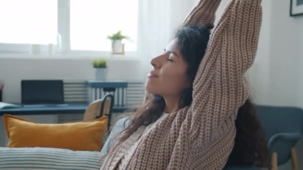 Cámara lenta de chica atractiva relajarse en el sofá en casa y luego siesta con los ojos cerrados — Vídeos de Stock