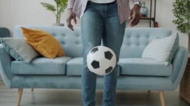 Evde futbol oynarken kulaklık takan Afro-Amerikan bir adamın yavaş çekimleri.