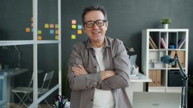 Neşeli ofis çalışanının yavaş çekimde portresi olgun bir adamın gülüşü ve sonra gözlüğünü çıkarışı.