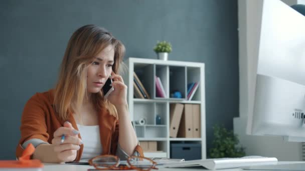 不幸なビジネス女性はオフィスで電話を持っているビジネスパートナーとの問題を議論しています — ストック動画