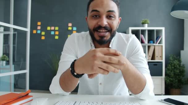 Porträt eines afroamerikanischen Geschäftsmannes, der im Internet Videotelefonate führt und dabei gestikulierend in die Kamera schaut — Stockvideo