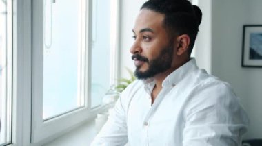 Orta Doğulu çekici bir adamın yavaş çekimde içki içmesi ve eve bakması.