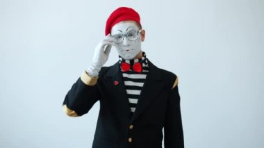 Gülümseyen pandomimistin yavaş hareket eden portresi baş parmak hareketi ve baş sallaması.