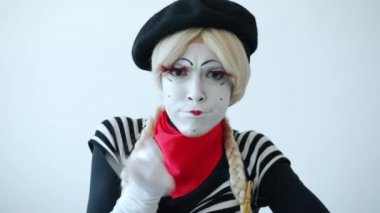 Genç kadın pandomimci parmağını sallıyor ve kafasını sallıyor. Ekrana bakıyor. Yani onaylamıyor.