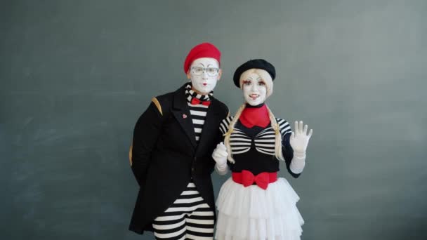 Retrato de casal feliz de mimes masculino e feminino acenando mão e sorrindo olhando para a câmera — Vídeo de Stock