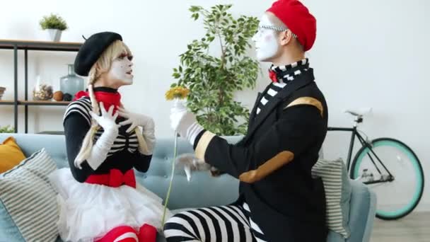 Ρομαντικό mime άνθρωπος δίνοντας λουλούδι σε γυναίκα στέλνοντας φιλί αέρα εκφράζοντας την αγάπη αγκαλιάζει σε εσωτερικούς χώρους στο διαμέρισμα — Αρχείο Βίντεο