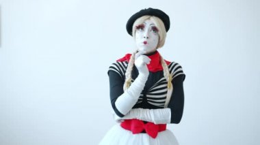 Sevimli bir pandomimci kız parmak kaldırmayı düşünüyor yaratıcı fikirleri düşünüyor ve tek başına duruyor.