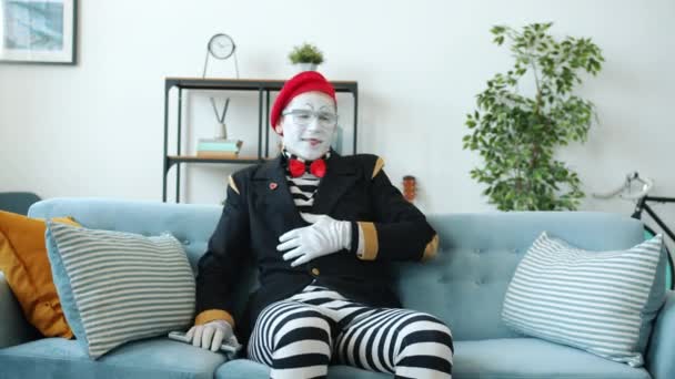 Mimare konstnär tittar på TV ändra kanaler som uttrycker känslor i lägenheten — Stockvideo