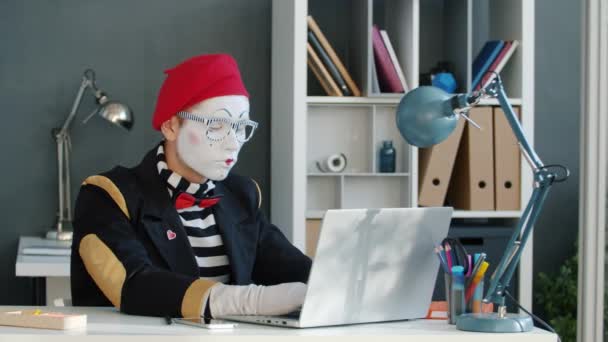 Mime empresário usando laptop enquanto secretária trazendo documento para assinar no escritório — Vídeo de Stock