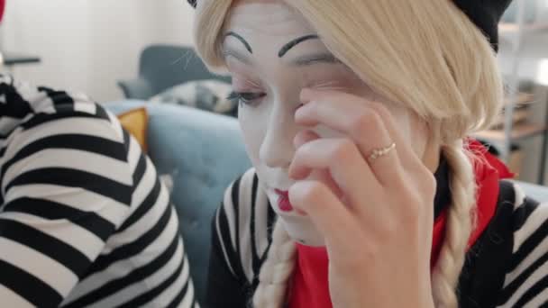 Mujer joven mimo artista eliminación de maquillaje y pintura de la cara después de la actuación — Vídeos de Stock