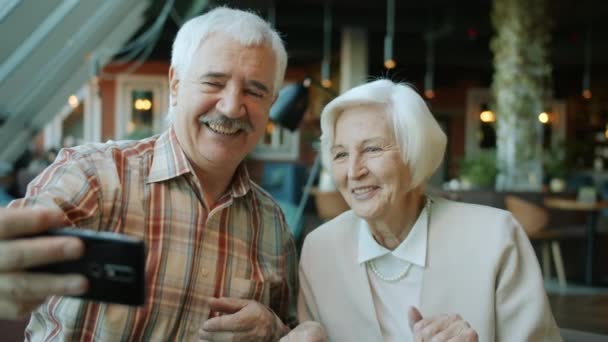 Lassú mozgás a gyönyörű idős pár, hogy szelfi okostelefon kamera étteremben — Stock videók