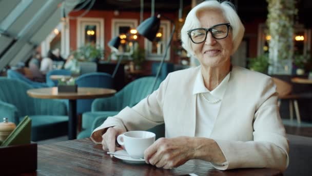 Porträtt av vackra senior affärskvinna ler och tittar på kameran i restaurang — Stockvideo