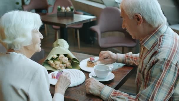 Pria dan wanita senior yang ceria makan kue dan minum teh di restoran — Stok Video