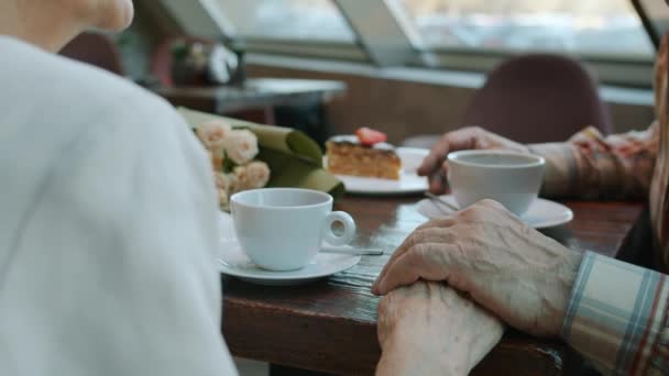 Idősek közeli lassított felvétele férfi és nő kéz a kézben a kávézóban — Stock videók