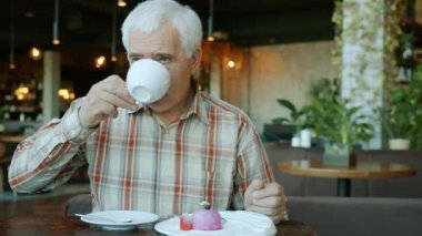 Çay içen yaşlı adamın portresi. Restoranda keyfine bakıyor.