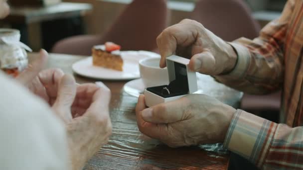 Primo piano al rallentatore di mani di uomini anziani aprire portagioie e dare anello alla donna anziana — Video Stock