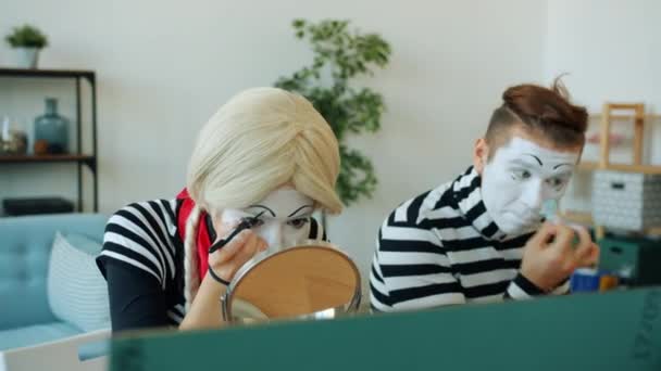 Ragazza e ragazzo pantomimisti utilizzando make-up e face-paint per creare prestazioni smorfie — Video Stock