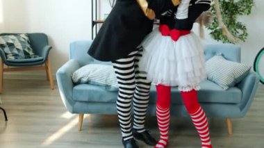 Mutlu erkek ve kadın pandomimciler şarkı söyleyip dans ediyorlar evde müzik dinliyorlar.