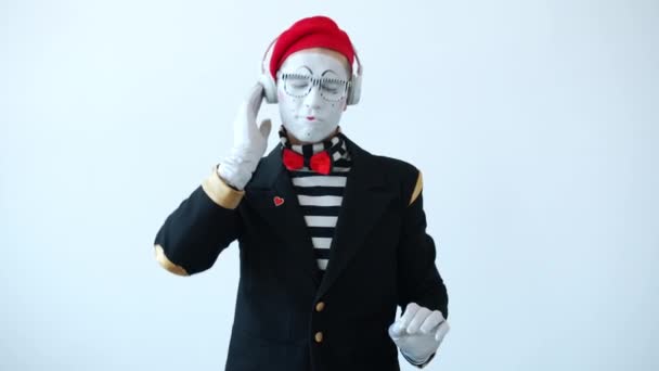 Portrait of funny mime wearing headphones dancing enjoying music on white background — Stock Video