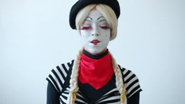 Güzel bayan pandomimcinin portresi yuvarlanan gözler ve beyaz arka planda gülümseme