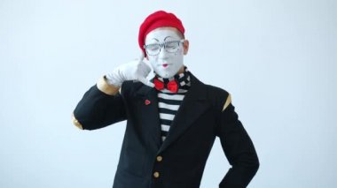 Komik pandomimci hayali cep telefonuyla konuşuyor kavga ediyor, bağırıyor ve gülümsüyor.