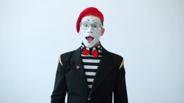 Yavaş hareket eden kostümlü pandomimist çığlık atıyor ve el sallayarak dikkat çekiyor.