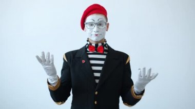 Mutsuz pandomimci aktörün yavaş çekimde baş aşağı el hareketi göstermesi beyaz arka planda başını sallaması