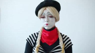 Beyaz arka planda hıçkıra hıçkıra ağlayan üzgün bir kızın ağır çekimde portresi.