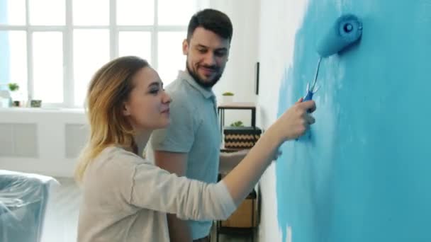 Playful guy having fun mit freundin touch sie nose mit dirty finger painting wall together — Stockvideo