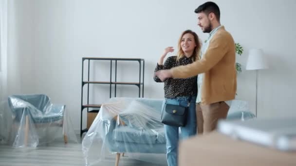 Giovane famiglia uomo e donna discutendo nuovo appartamento in piedi in casa parlando e gesticolando — Video Stock