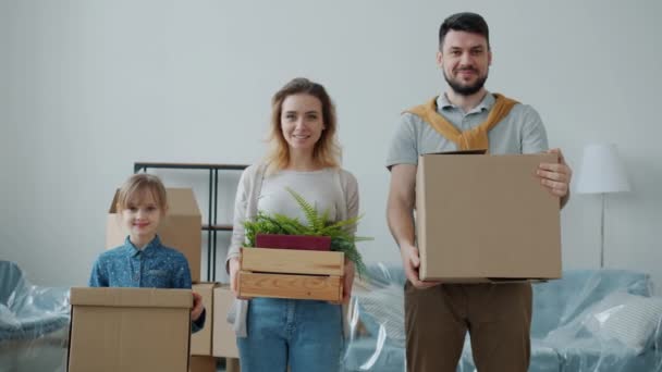 Homem mulher e menina feliz família segurando caixas durante a mudança para novo apartamento — Vídeo de Stock