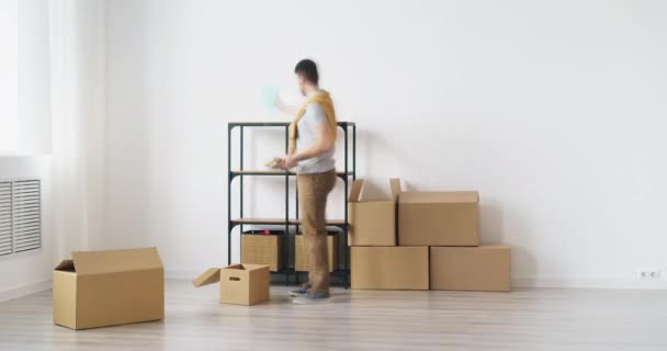 Tempo-lapso de jovem casal trazendo caixas para casa vazia decoração interior, em seguida, relaxar no sofá — Vídeo de Stock