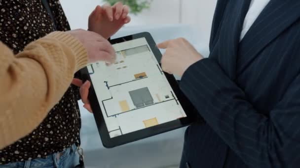 Крупним планом планшет з планом квартири і рук брокер і клієнти торкаються екрану — стокове відео