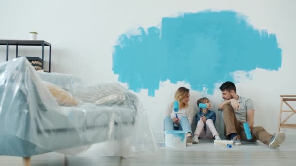 Movimento lento do homem mulher e criança conversando e fazendo high-five relaxante durante a renovação da casa — Vídeo de Stock