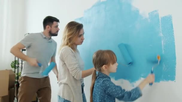 Glückliche Familie genießt Wohnungsrenovierung Malerei Wand und Tanzen Spaß zusammen — Stockvideo