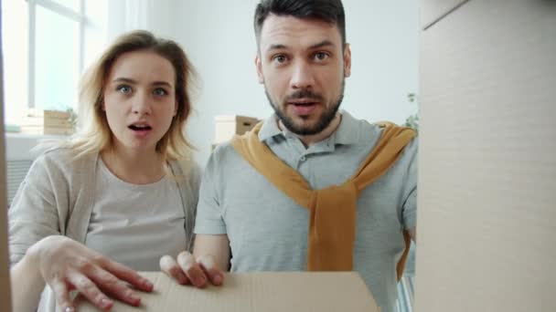 Πορτρέτο του έκπληκτος νεαρό ζευγάρι άνοιγμα κουτί κοιτάζοντας μέσα με σοκαρισμένη έκφραση στη συνέχεια το κλείσιμο — Αρχείο Βίντεο