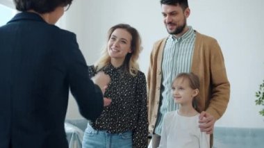 Çocuğu olan genç bir aile emlakçıdan anahtar alıyor. El sıkışıyor, heyecanlanıyor.