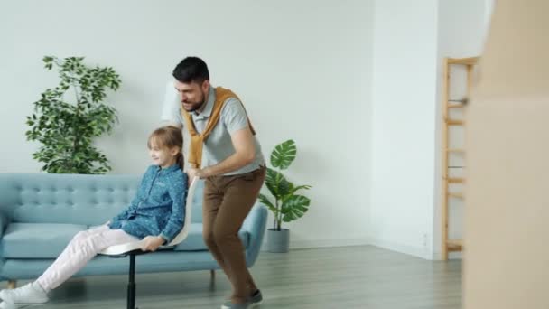 Milující otec na koni židle s roztomilou dceruškou pak objímání líbání vyjadřující lásku v novém bytě — Stock video