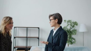 Yeni dairede genç ve mutlu bir çiftle konuşan kadın emlakçı yavaş hareket ediyor.