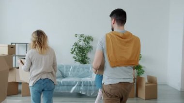 Mutlu bir ailenin yeni eve kutular getirmesi koltukta dinlenmesi öpüşmeleri.