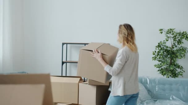 Marido e esposa carregando caixas de papelão movendo pertences durante a mudança para a nova casa — Vídeo de Stock