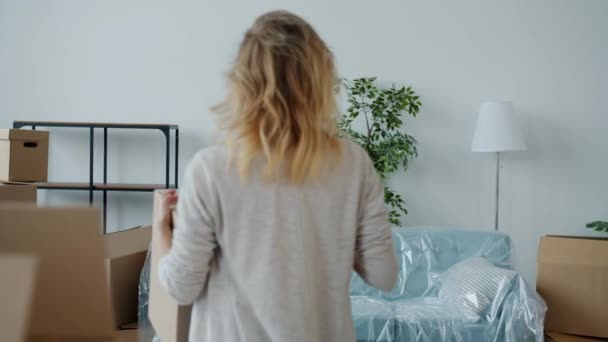 Slow motion of girl and guy carrying cardboard boxes to new house then doing high-five and hugging — Stock Video