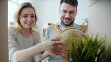 Güzel bir çiftin portresi taşınırken eşyaları yerleştirirken eşyaları kucaklıyor, konuşuyor ve öpüşüyorlar.