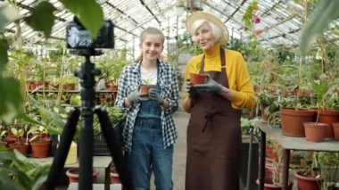 Büyükanne ve torun vlog kaydediciler serada başparmak hareketi gösteren video kayıt