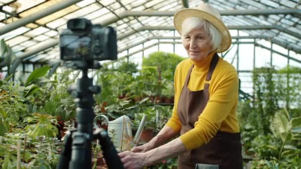 Ηλικιωμένη blogger καταγραφή βίντεο για online blog μιλώντας για φυτά στο θερμοκήπιο — Αρχείο Βίντεο