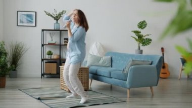 Modern evde dans eden ve şarkı söyleyen çılgın hamile kadının ağır çekimde